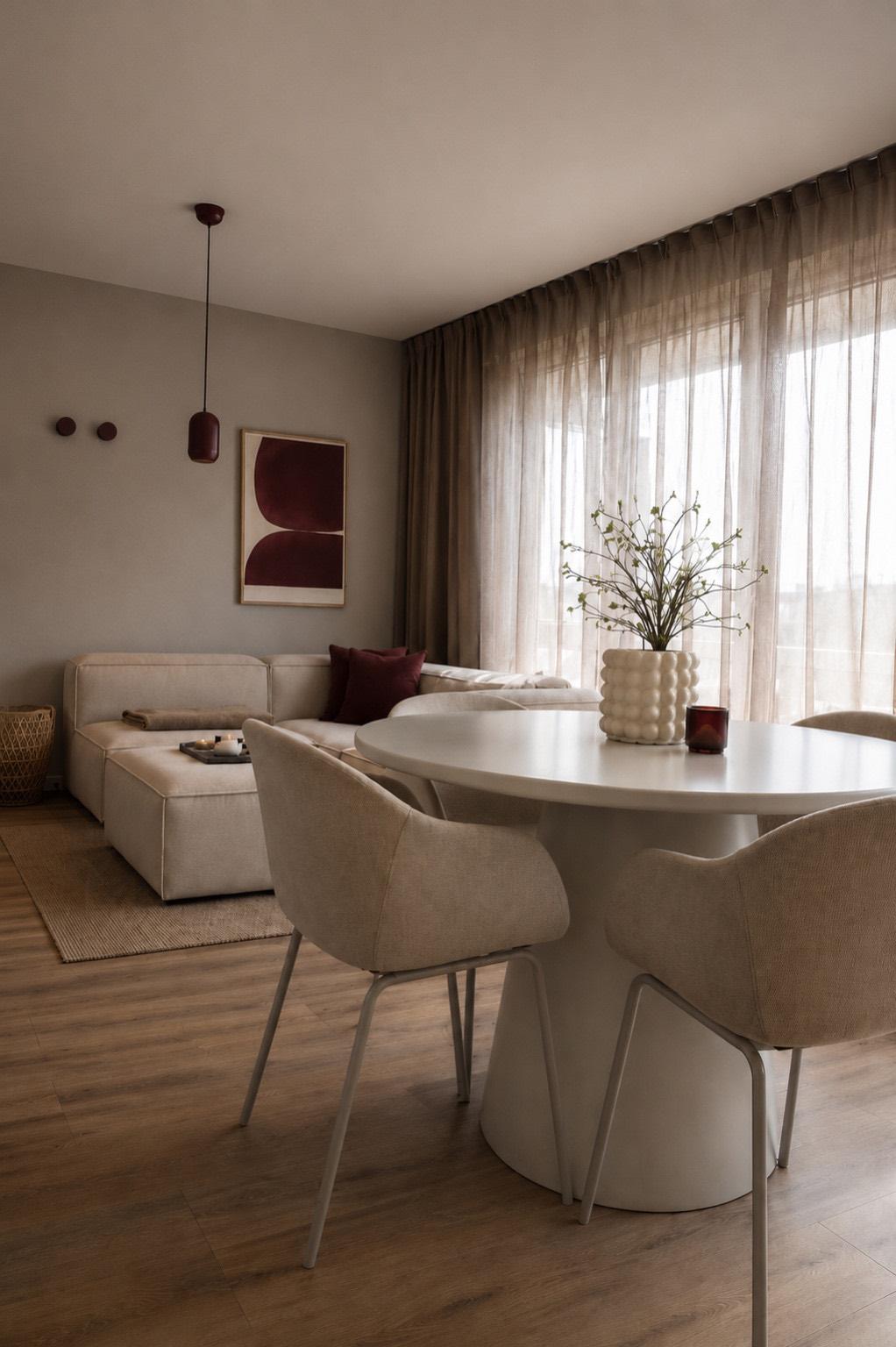 Zachte beige woonkamer met bordeauxrode accenten in project Den Haag